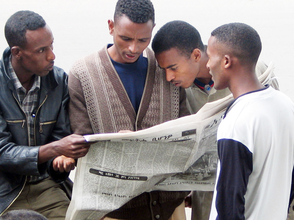 Black men reading foreign language newspaper